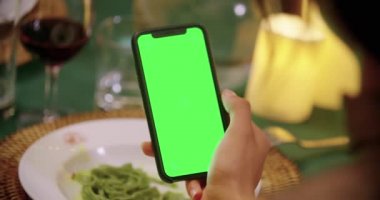 Zarif gurme gece yemeği sırasında yeşil ekran akıllı telefon cihazı kullanan kadın. Umbria.4k yavaş hareket Arkadaşlar İtalyan gezisi