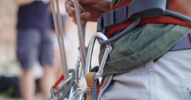 Bergsteiger bereitet sich mit Karabiner auf den Aufstieg in die Felswand vor. Klettern extreme aktive sportliche Aktivität. Aktive Menschen, Outdoor-Aktivitäten. side detail.slow motion 4k video. — Stockvideo