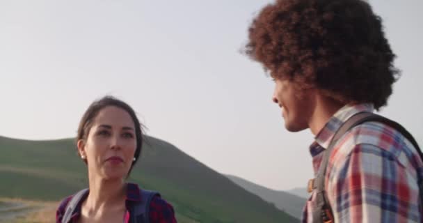 Dos personas pareja en amor hombre y mujer mirando paisaje panorama.Hiking con bastones de trekking o nordic caminar al aire libre en un sendero al atardecer o al amanecer. — Vídeo de stock