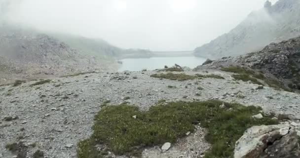 Baraj yapay göl yakınında tırmanma İtalyan Alpleri dağ riff üzerinde havadan kurma uçuş. Sisli veya bulutlu havalarda vahşi yeşil doğa açık havada. 4k drone kamyon üzerinde — Stok video