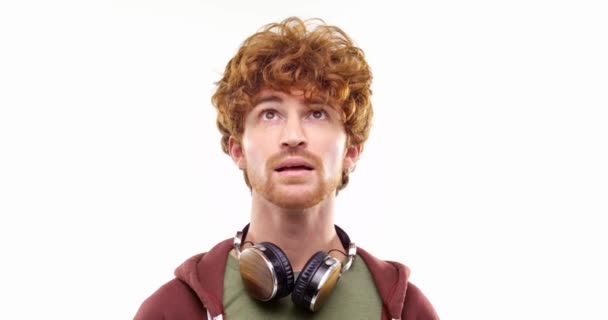 Beautiful happy fun young adult redhead man listening to music by headphones, doing happy, serious, surprised, curious expressions.One person.People portrait isolated on white background.Medium shot — стоковое видео