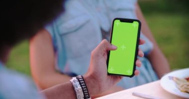 Gün batımında romantik açık akşam yemeği sırasında yeşil ekran akıllı telefon cihazı kullanarak Adam . Umbria.4k yavaş hareket Arkadaşlar İtalyan gezisi