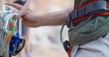 Dağcı adam karabina alarak kayalık duvar yarığına tırmanmaya hazırlanıyor. Aşırı aktif spor aktivitesi tırmanma. Aktif insanlar, açık hava etkinlikleri. Yan detay. Yavaş çekim 4k video.