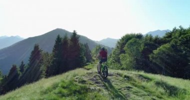 Bisikletçi yaz güneşli bir günde orman izi boyunca akıllı telefon havadan sürme dağ bisikleti ile bir resim çekiyor. Kros bisikletçisi. Mtb bisiklet inde akıllı telefon kullanan adam. Cep telefonu kullanan adam