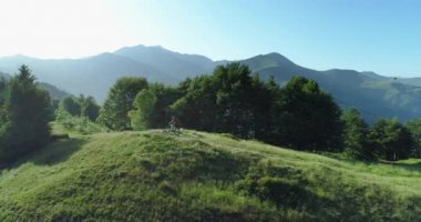 Bisikletçi yaz güneşli bir günde orman izi havadan görünümü boyunca dağ bisikleti sürme. Kros bisikletçisi. Anten Mtb bisiklet ipe biniyor. Dağlarda yol boyunca binicilik dağ e-bisiklet