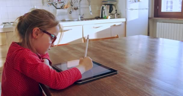 Menina desenho no tablet em casa. Criança que atrai o dispositivo de pastilha na cozinha na educação à distância. Menina fazendo lição de casa em tablet. Educação inteligente. Escola em casa. Ensino à distância — Vídeo de Stock