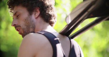 Adam kürekleri ya da kürekleri tutuyor ve konuşuyor rafting ya da kano yapmadan önce dalış kıyafeti giyip etrafa bakıyor. Aksiyon sporu. Dostlar İtalya gezisi Umbria 44k yavaş çekim