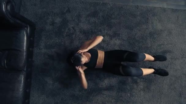 Pohled shora na ženu, která doma cvičí na podlaze. Nad hlavou ženy, které doma trénují fitness. Ženský tréninkový svaly. Dům průmyslového stylu — Stock video