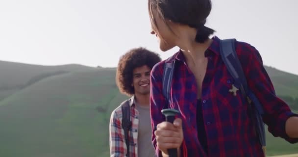 Randonnée pédestre homme et femme en utilisant des pôles de trekking. Marche nordique en plein air sur un sentier près des champs de fleurs à Castelluccio di Norcia.Voyage des amis italiens en Ombrie dans la journée ensoleillée. Mouvement lent 60 ips portable — Video