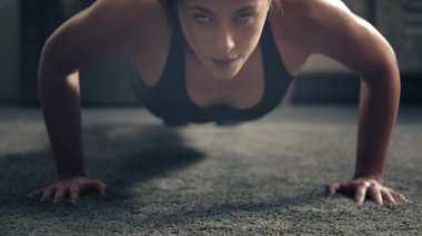 Evde yerde egzersiz yapan bir kadın. Evde şınav çeken bir kadın. Yerde kadın fitness eğitimi. Endüstriyel ev