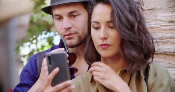 Dva turisté používají smartphone, aby udělali selfie ve venkovském městě Spello. Portrét středního výstřelu. Tro lidé dělat selfie venku.Friends italský výlet v Umbria.4k zpomalení — Stock video