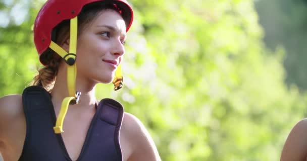 Γυναίκα φορώντας σωσίβιο και αθλητικό κράνος χαμογελώντας και γελώντας πριν από το ράφτινγκ ποταμού κατάβαση.Ομάδα ανθρώπων ενημέρωση πριν από την έναρξη της ακραίας αθλητικής δραστηριότητας.Rafting extreme sport.Handheld. — Αρχείο Βίντεο