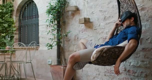 Man sleeping on hanging chair.Rural home. Slow motion handheld shot. Man relaxing on hanging chair. Man sleeping on hammock. — Stock Video