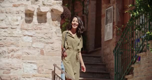 Cuatro turistas felices caminando por la pequeña calle visitando la ciudad rural. Grupo de personas multiétnicas caminando en el casco antiguo.Amigos viaje de vacaciones en Italy.4k cámara lenta.Clima soleado — Vídeo de stock