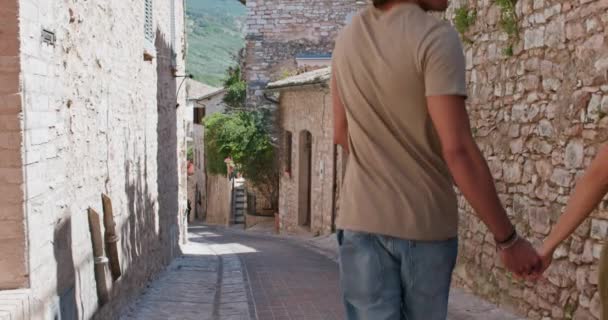 Quattro turisti felici passeggiando per la piccola strada visitando città rurale.Indietro seguire. Gruppo di persone multietniche che passeggiano nel centro storico.Viaggio vacanza amici in Italia.4k slow motion — Video Stock