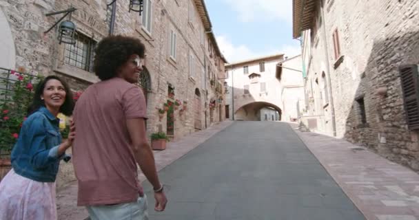 Romantisch koppel dat een bezoek brengt aan het landelijke stadje Assisi.Omdraaien. Vrienden Italiaanse reis in Umbrië.4k slow motion — Stockvideo