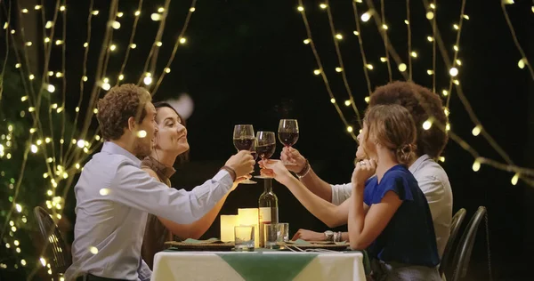 Vier Personen, zwei Paare, die bei einem romantischen Gourmet-Dinner oder Mittagessen fröhlich miteinander reden und essen. Freunde auf Italienreise — Stockfoto