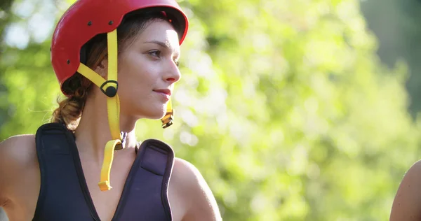 Mujer vistiendo chaleco salvavidas y casco deportivo sonriendo antes de rafting descenso del río.Grupo de personas informando antes de comenzar la actividad deportiva extrema.Rafting deporte extremo.Handheld. — Foto de Stock