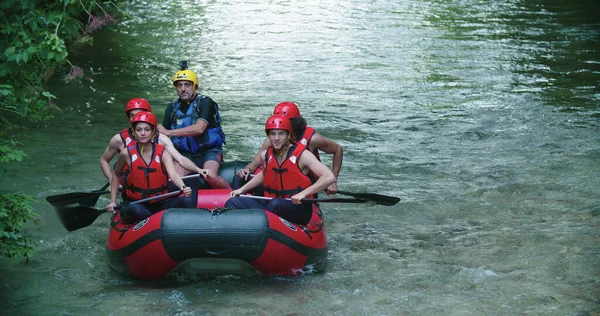 Gruppo di persone in gommone che fanno rafting sul fiume Whitewater durante il tramonto o l'alba. Retroilluminazione calda. Amici viaggio in italiano — Foto Stock