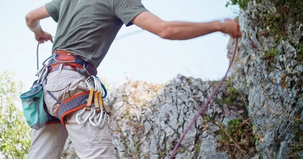 Climber man preparing for climbing up the rocky wall rift by checking rope. Climbing extreme active sport activity. Active people, outdoor activities.Body medium shot. — Stock Photo, Image