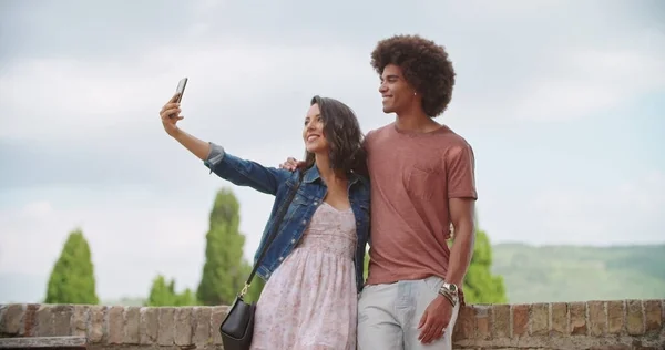 Romantisch koppel neemt een selfie met smartphone in het landelijke stadje Assisi.approach breed shot.Friends Italiaanse reis — Stockfoto