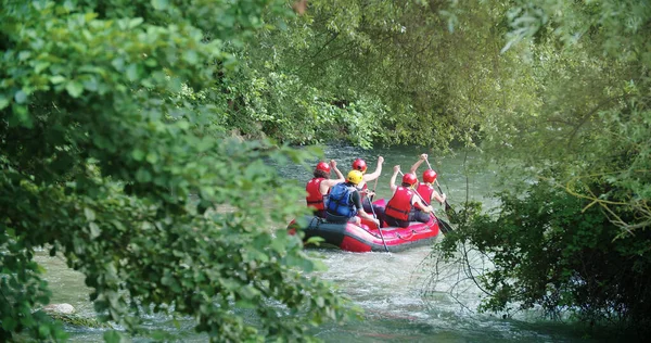 Gruppo di persone in gommone che fanno rafting sul fiume Whitewater durante il tramonto o l'alba. Retroilluminazione calda. Amici viaggio in italiano — Foto Stock