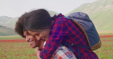  Erkek omuzlarında bir kadınla yürür. Yan görünüş yakın. Dışarıda yürürken omuzlarında bir kadın. Yan görüş detayı. Gülümseyen bir kadınla yürüyen mutlu bir adam.