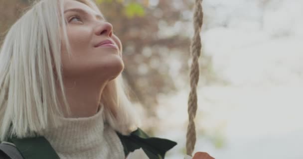 Jeune belle femme balançant et souriant dans une journée d'automne. Mouvement lent — Video