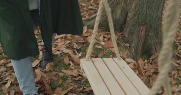 Détail des jambes de la jeune femme marchant pour se balancer et s'asseoir. Belle femme blonde se balançant et s'amusant sous un grand arbre. au ralenti — Video