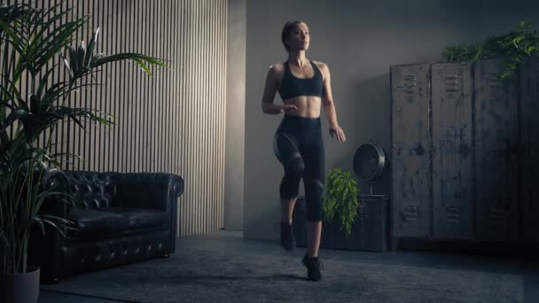 Atlétikai nő magas térdgyakorlatot végez otthon. Otthoni edzés. Otthoni fitnesz. Van egy kis köd a levegőben. Lassú mozgás. — Stock videók