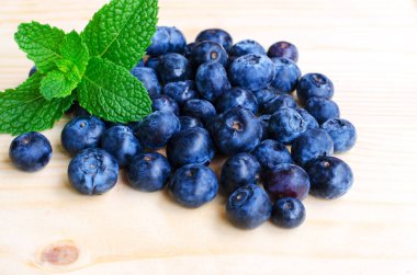 Ahşap zemin üzerinde nane aromalı taze yabanmersini.