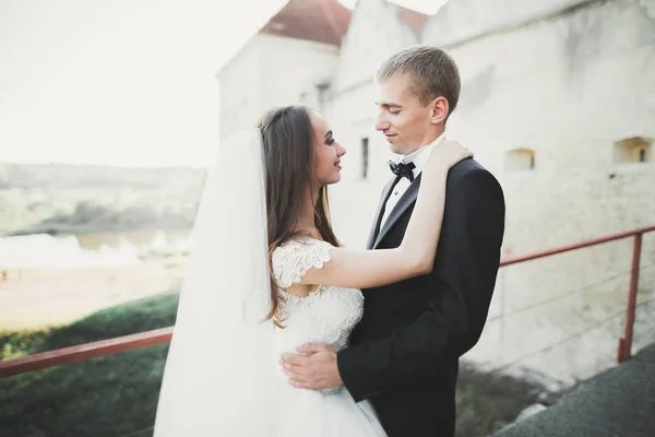 Beautiful romantic wedding couple of newlyweds hugging near old castle — Stock Photo, Image