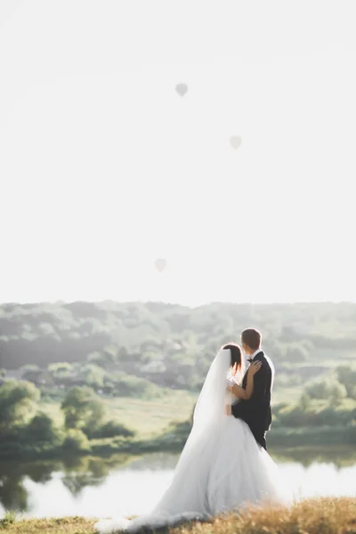 Cuplul de nuntă pozând la apus în ziua nunţii. Mireasă și mire în dragoste — Fotografie, imagine de stoc