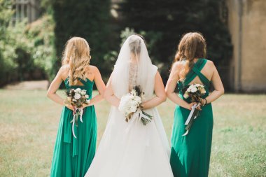 Gelin çiçekli büyük ve güzel bir düğün buketi tutuyor.