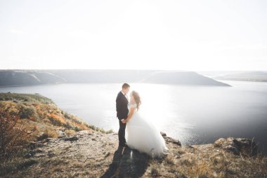 Güzel bir sahilde poz veren genç bir çiftin mutlu ve romantik sahnesi.