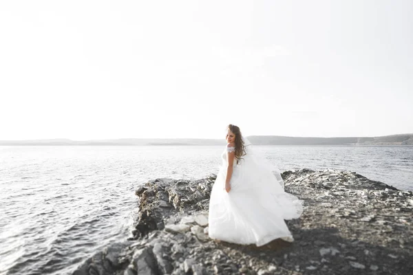 Romantische mooie bruid in witte jurk poseren op de achtergrond zee — Stockfoto