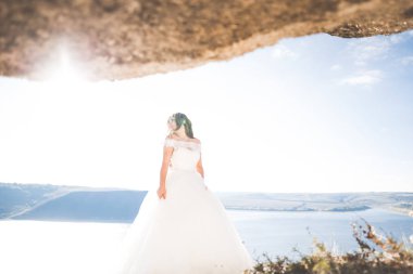 Arka planda beyaz elbiseli romantik gelin pozu