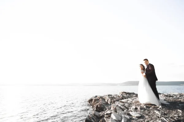 Élégant couple de mariage heureux élégant, mariée, marié magnifique sur le fond de la mer et le ciel — Photo