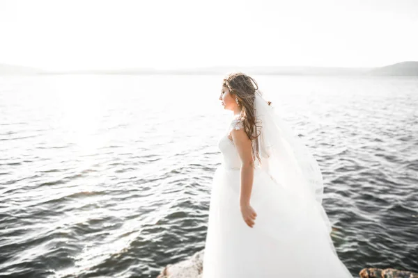Mooie jonge bruid poseren op de achtergrond-zee — Stockfoto