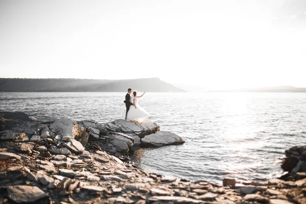 Elegante elegante coppia di nozze felice, sposa, splendido sposo sullo sfondo del mare e del cielo — Foto Stock