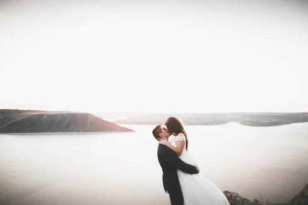 Glückliche und romantische Szene von frisch verheirateten jungen Hochzeitspaaren, die am schönen Strand posieren — Stockfoto