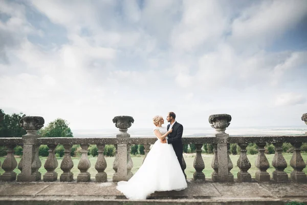 Hermosa boda romántica pareja de recién casados abrazos cerca del viejo castillo —  Fotos de Stock