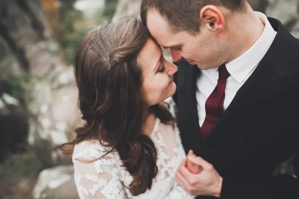 Wedding couple in love kissing and hugging near rocks on beautiful landscape — Stock Photo, Image