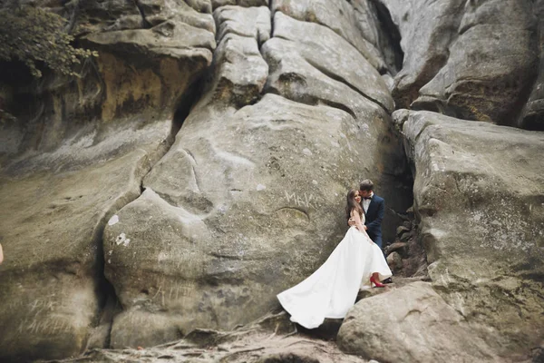 아름다운 경치에 사랑의 입맞춤을 하고 바위 근처에서 껴안고 있는 부부 — 스톡 사진