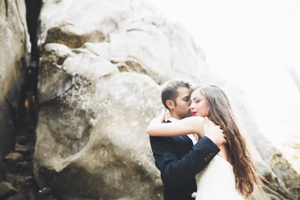 Linda noiva, noivo beijando e abraçando perto das falésias com vistas deslumbrantes — Fotografia de Stock