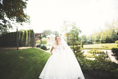 Gelinlik içinde dışarıda poz veren güzel gelin.