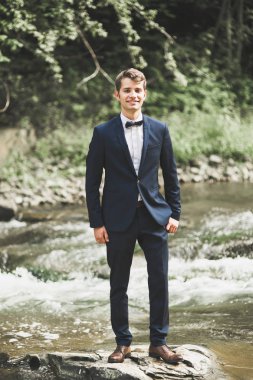 Mutlu yakışıklı delikanlı, damat açık havada poz