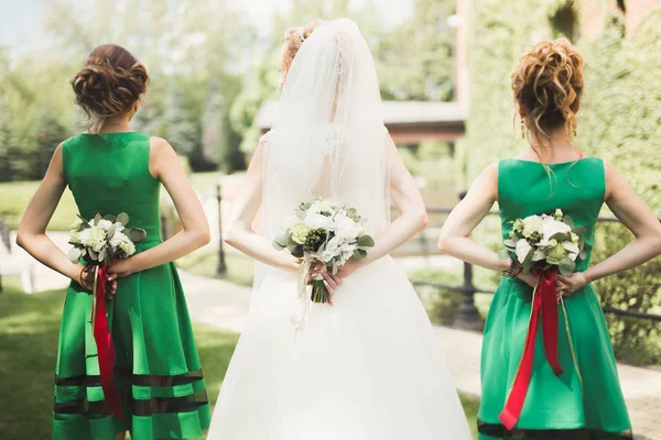 Gelin çiçekli büyük ve güzel bir düğün buketi tutuyor.