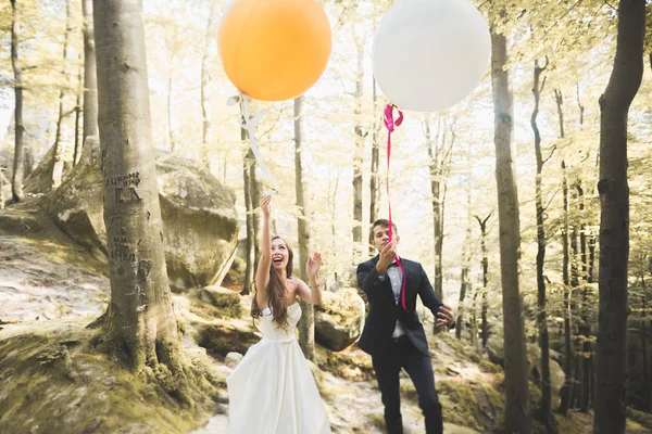 Pár mladých legrační šťastný svatba venku s balónky — Stock fotografie