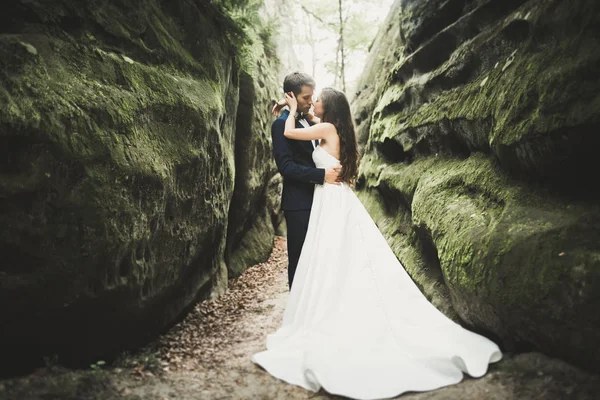 Couple de mariage heureux embrasser et étreindre près d'une haute falaise — Photo